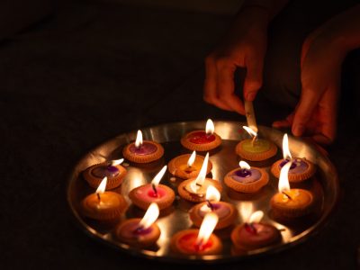 hands-lighting-diyas-in-a-tray-2024-12-02-07-49-36-utc